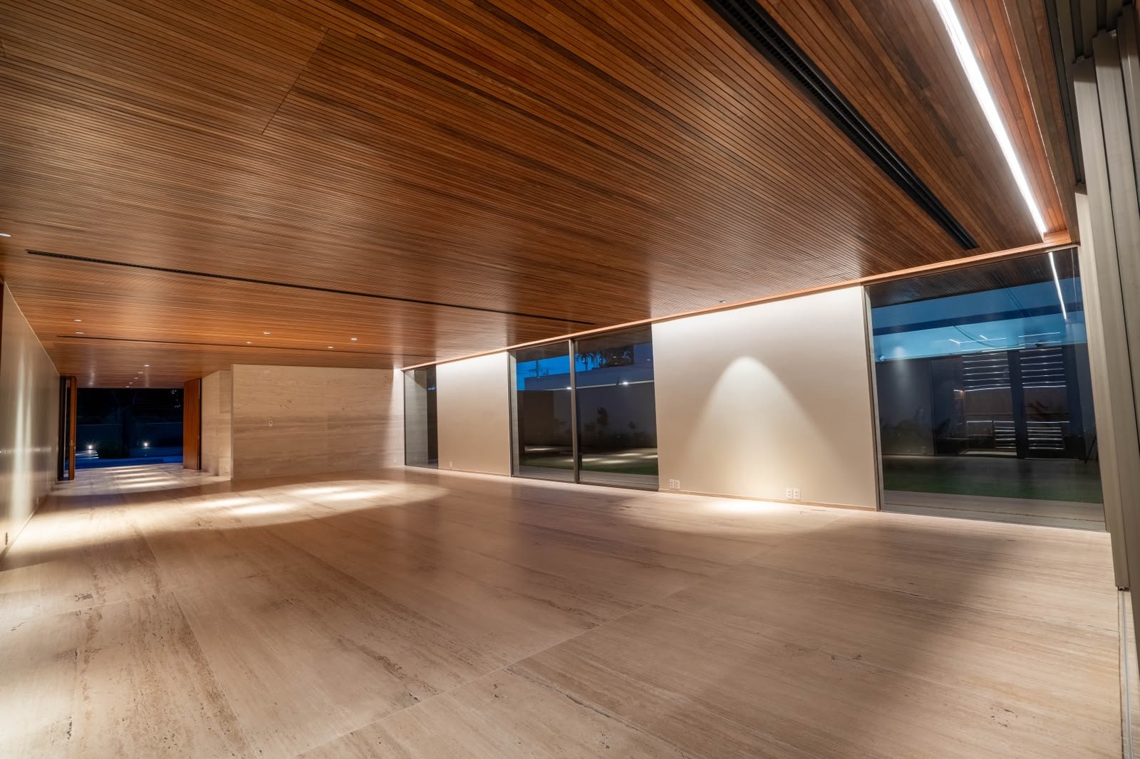 Sala ampla com iluminação embutida e painéis em madeira
